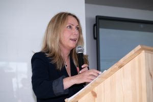 Person speaking at a podium with a microphone.