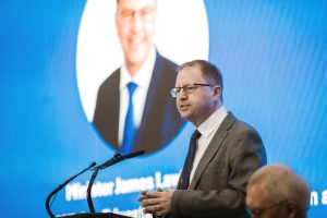 Minister James Lawless speaking at a microphone. 