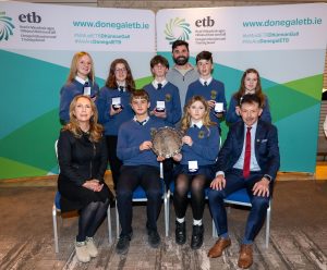 Group of students and staff holding a plate. 