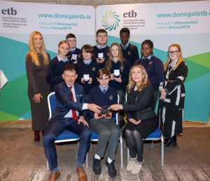 Group of students and adults holding a bowl. 