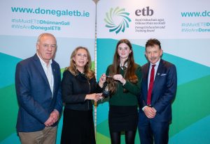 Students and three adults holding a cup. 